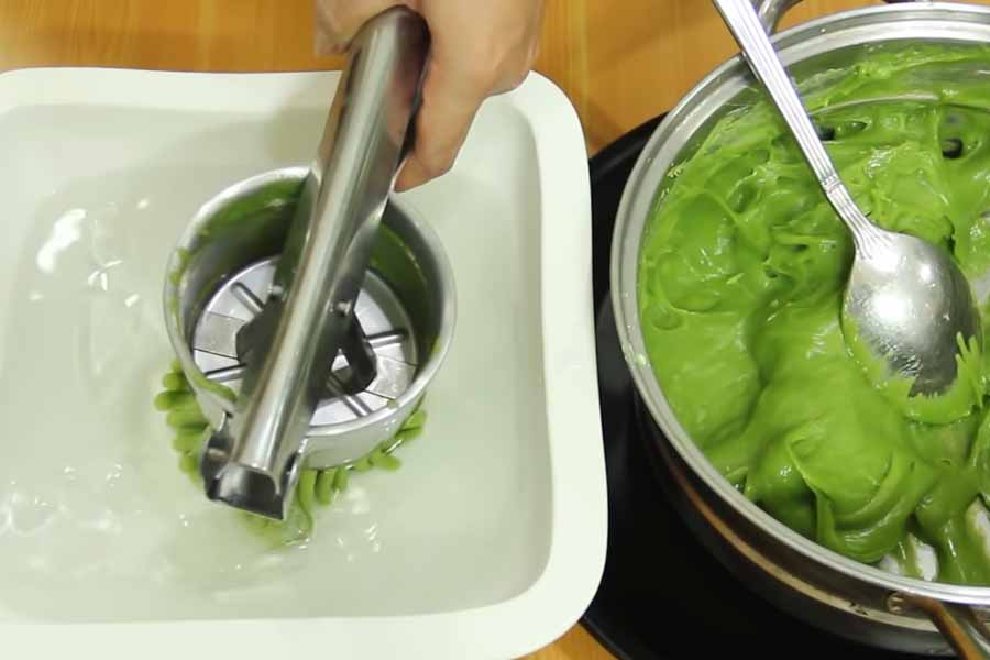 Cho bột vào khuôn rồi ép thành các sợi bánh lọt mỏng